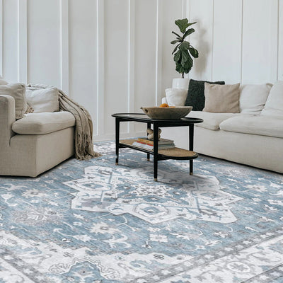 Eldora Vintage Washable Rug in a living room setting. Featuring a blue and gray intricate pattern, made of 100% Polyester.