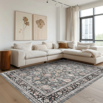 Eclipse Persian washable area rug in a living room setting, gray and black floral pattern with pink accents.